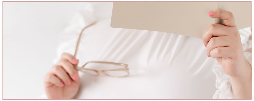 Female Coach looking at note book, holding glasses