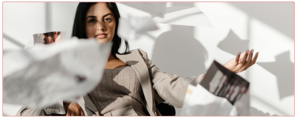 woman in her office throwing papers in the air